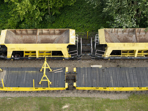 Aerial view of yellow hopper cars and flatbed train cars at a train repair station in Krakow, Lesser Poland Voivode, Poland.