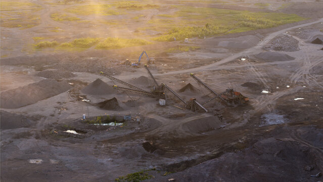 Aerial view of a mining site with conveyor belts and heavy machinery operating in a quarry at sunset in Krakow, Lesser Poland Voivode, Poland.