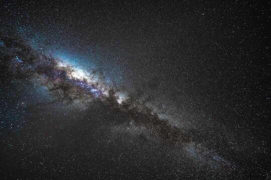 Namibia Desert, Namibia - 10 September 2023: View of the Milky Way galaxy stretching across the dark night sky above the desert landscape.