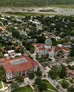 Aerial view of the Memorial Presbyterian Church with its distinctive dome and red-tiled roofs surrounded by historic buildings and lush greenery in St. Augustine, Florida, United States.