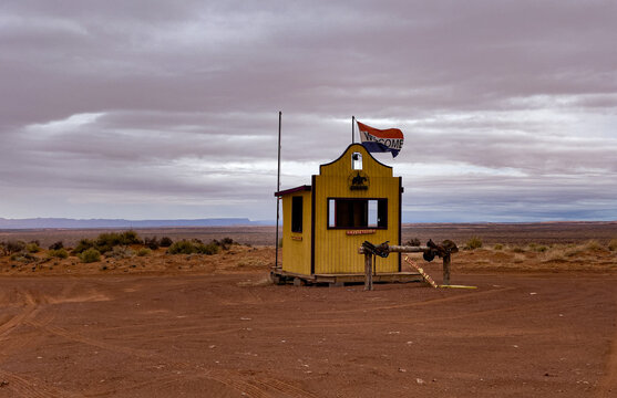 View of a yellow wooden booth at the entrance to Monument Valley Tribal Park under a cloudy sky in Oljato-Monument Valley, Utah, United States.