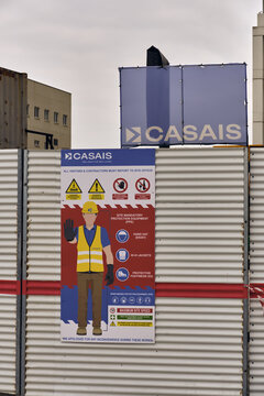 Gibraltar, Gibraltar - 01 March 2026: View of a Casais construction site safety sign at the Victoria Stadium reconstruction project, featuring PPE requirements and warnings on metal fencing.