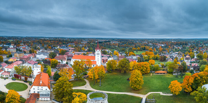 Aerial view of Cesis Castle and St. John's Church surrounded by vibrant autumn foliage and historic buildings in the town of Cesis, Cesis Municipality, Latvia.