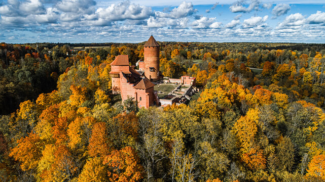Aerial view of Turaida Castle surrounded by vibrant autumn foliage and dense forest in Sigulda, Sigulda Municipality, Latvia.