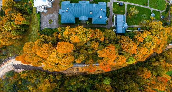 Aerial view of Sigulda New Castle surrounded by vibrant autumn foliage and lush trees in Sigulda, Sigulda Municipality, Latvia.