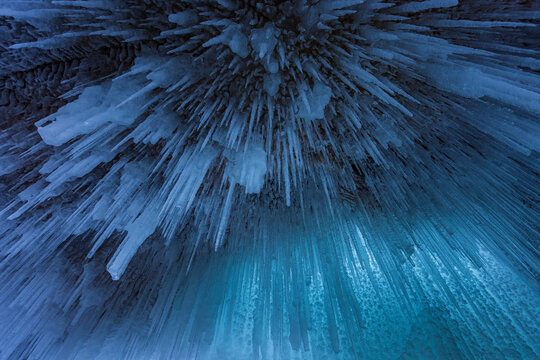 View of intricate ice formations and icicles hanging from the ceiling of a frozen cave at Lake Baikal in Khuzhir, Irkutsk Oblast, Russia.