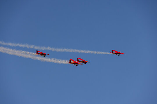 Druskininkai, Lithuania - 23 May 2026: View of red aerobatic planes flying in formation against a clear blue sky leaving white smoke trails.