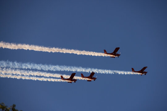 Druskininkai, Lithuania - 23 May 2026: View of four red airplanes flying in formation with white smoke trails against a clear blue sky.