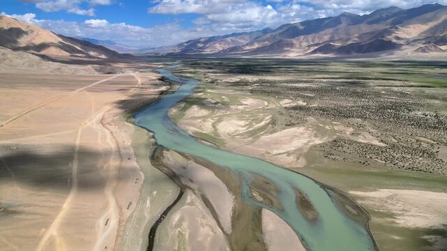 Aerial view of the Indus River winding through the arid, mountainous landscape of the Ladakh region near Dungti, Ladakh, India.