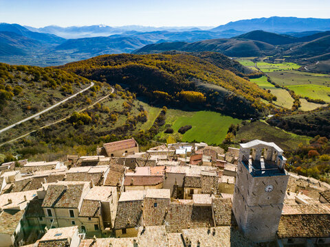 Aerial view of the historic village with its stone rooftops and clock tower, nestled in the mountainous landscape of the Abruzzo region in Castel del Monte, Abruzzo, Italy.