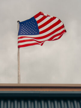 American flag waving against a bright sky