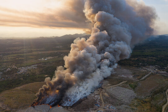 Aerial view of Vertedero Duquesa landfill fire with thick smoke billowing into the sky over the landscape in Pantoja, Santo Domingo, Dominican Republic.