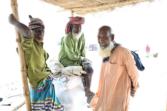 Gaibandha District, Rangpur Division, Bangladesh - 15 February 2026: View of three elderly men in traditional clothing resting under a bamboo shelter at Char Krishnamani.
