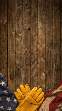Work gloves with the American flag on wooden background. Symbolic of blue collar workers, USA manufacturing, pride in products Made in United States of America, or for Father's day or US Labor Day.