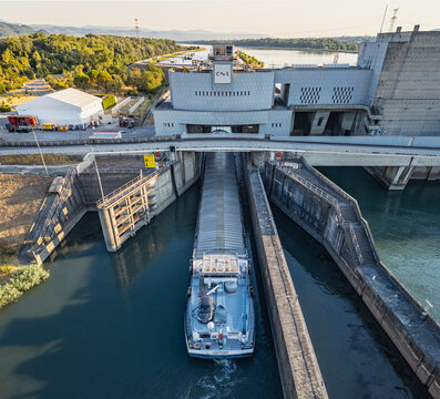 Saulce-sur-Rhone, Auvergne-Rhone-Alpes, France - 12 July 2026: Aerial view of a cargo barge in the Logis Neuf navigation lock at the CNR hydroelectric power station.