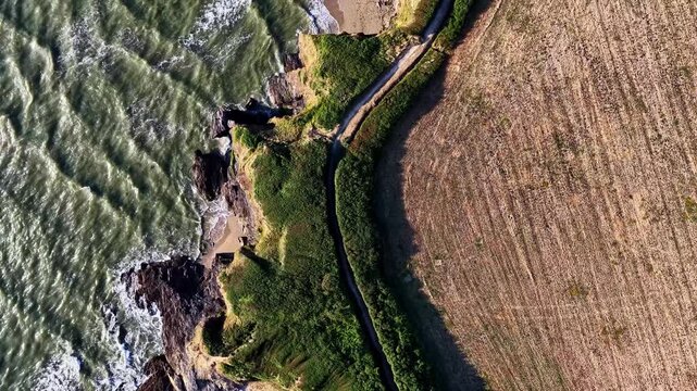 Aerial view of Plage de la Marche aux Boeufs with rocky cliffs, sandy beach, and agricultural fields in Asserac, France.