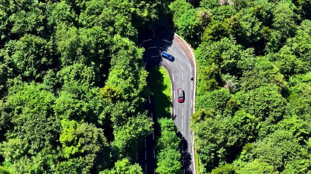 Aerial view of the winding road at Col d'Aubisque surrounded by dense green forest in Beost, Nouvelle-Aquitaine, France.
