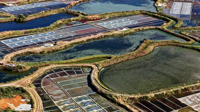 Aerial view of salt marshes with geometric pans, water channels, and earthen dikes in Capbreton, Nouvelle-Aquitaine, France.