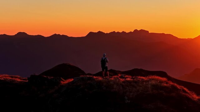 Aerial view of a hiker walking along the mountain ridge at sunset at Col d'Aubisque in Beost, Nouvelle-Aquitaine, France.