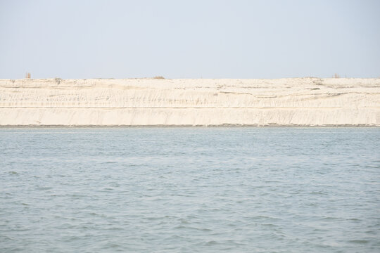 Gaibandha District, Rangpur Division, Bangladesh - 17 February 2026: View of Char Krishnamani, a sandy river island featuring layered sediment banks along the river under a clear sky.