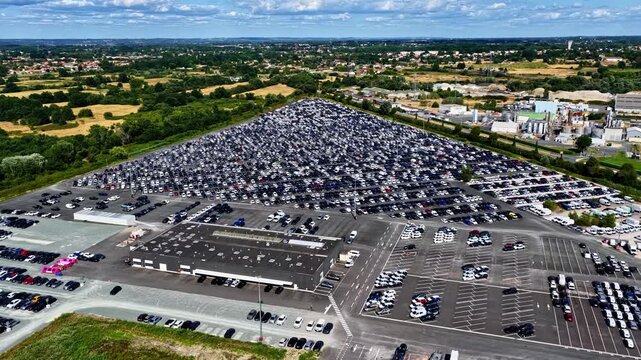 Aerial view of the Port of Bordeaux vehicle terminal with rows of parked cars and industrial infrastructure in Bassens, Nouvelle-Aquitaine, France.