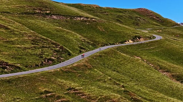 Aerial view of cyclists riding on the winding mountain road of Col d'Aubisque in Beost, Nouvelle-Aquitaine, France.