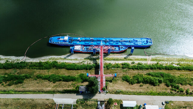 Aerial view of Luka Novi Sad with a blue tanker barge moored at the industrial pier along the Danube river in Novi Sad, Vojvodina, Serbia.