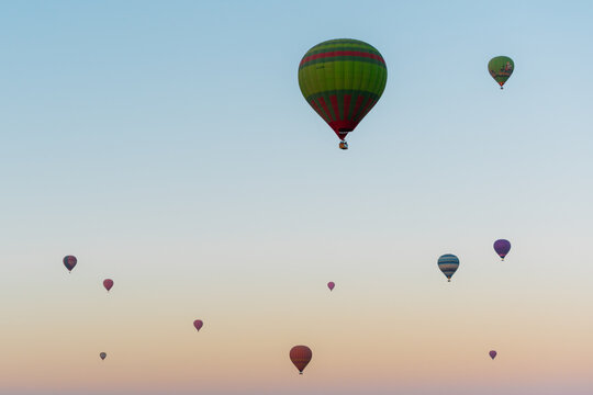 View of colorful hot air balloons floating in the clear sky at sunrise over Marrakesh, Marrakesh-Safi, Morocco.