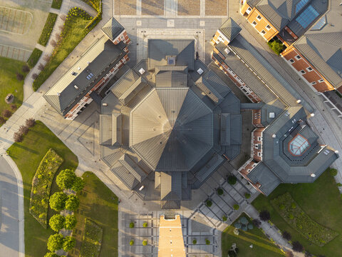 Aerial view of the basilica church featuring a large octagonal roof, surrounded by paved courtyards, green lawns, and historic brick buildings in Krakow, Lesser Poland Voivode, Poland.