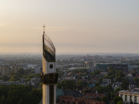 Aerial view of the Sanctuary of Divine Mercy tower with its modern architecture and cross overlooking the urban cityscape of Krakow, Lesser Poland Voivode, Poland.