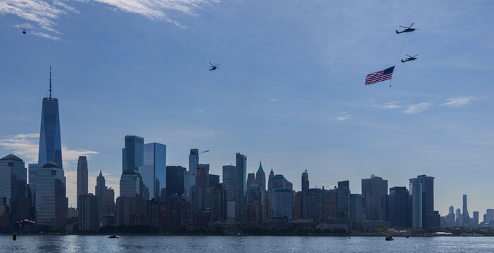 Jersey City, New Jersey, United States - 04 July 2026: View of Liberty State Park with helicopters flying over the Hudson River carrying an American flag in front of the Manhattan skyline.