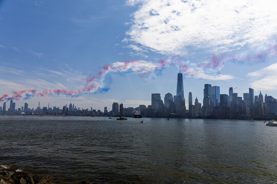 Jersey City, New Jersey, United States - 04 July 2026: View of the Manhattan skyline from Liberty State Park, with a red, white, and blue smoke trail in the sky.