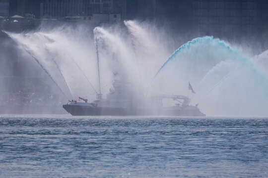 Jersey City, United States - 04 July 2026: View of a fireboat performing a water salute near Liberty State Park with powerful streams of water spraying into the air.