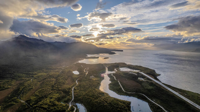 Aerial view of Dientes de Navarino mountains and Beagle Channel at sunset, featuring coastal roads and the local airport runway in Puerto Williams, Magallanes and Chilean Antarctica, Chile.