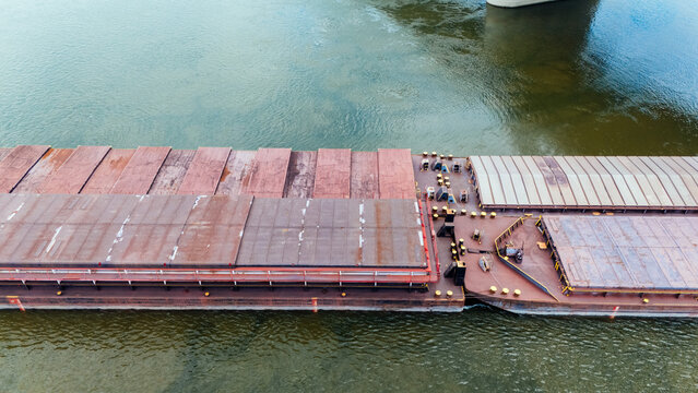 Aerial view of The New Zezelj Bridge spanning the Danube River with a large cargo barge navigating the waters below, Novi Sad, Vojvodina, Serbia.