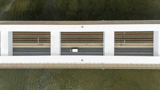 Aerial view of Zezelj Bridge with railway tracks and a road carrying a white van crossing the Danube River in Novi Sad, Vojvodina, Serbia.