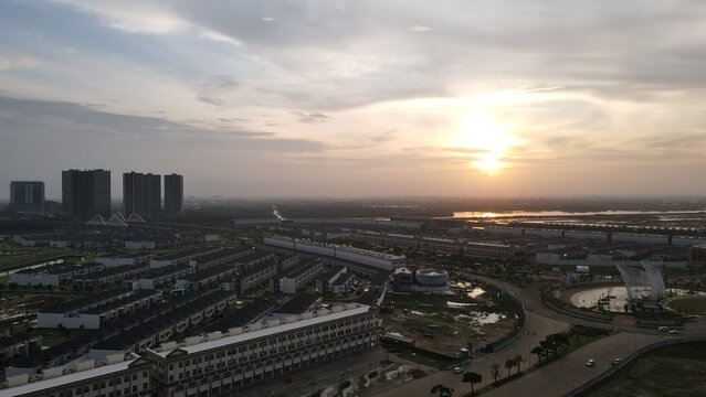 Aerial view of Golf Island in PIK featuring modern buildings and urban infrastructure under a sunset sky in Kecamatan Penjaringan, Daerah Khusus Ibukota, Indonesia.