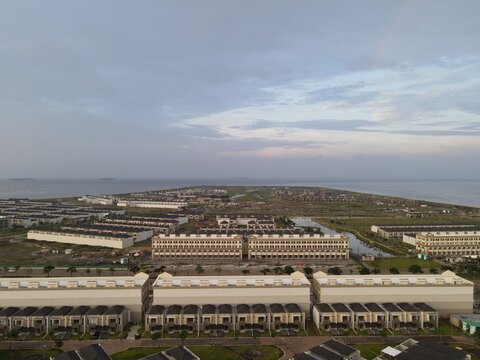 Aerial view of modern residential housing on Golf Island in PIK, featuring rows of buildings and coastal surroundings in Kecamatan Penjaringan, Daerah Khusus Ibukota, Indonesia.