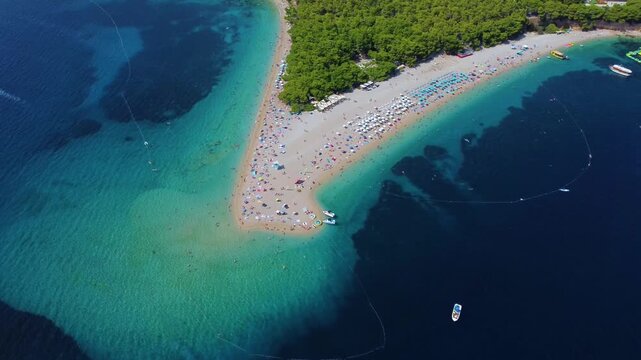 Aerial view of Golden Horn Beach with turquoise water, pebble shore, and pine forest in Bol, Split-Dalmatia County, Croatia.