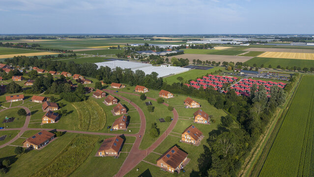 Aerial view of the Centraal Orgaan opvang Asielzoekers COA facility, featuring residential buildings, green lawns, and agricultural fields in Luttelgeest, Flevoland, Netherlands.