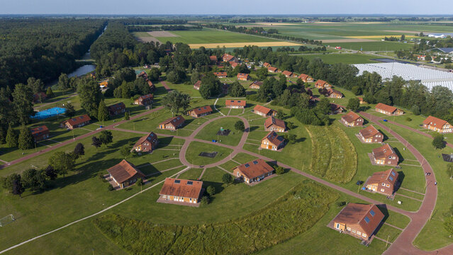 Aerial view of the Centraal Orgaan opvang Asielzoekers COA Luttelgeest with residential buildings, red roofs, green lawns, and paved paths in Luttelgeest, Flevoland, Netherlands.