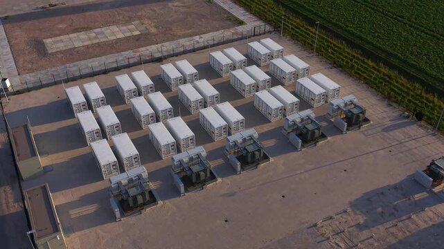 Aerial view of a battery energy storage system with rows of white containers and electrical equipment on a paved site in Dronten, Flevoland, Netherlands.