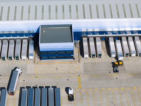 Aerial view of commercial distribution centres, warehouses and HGV logistics with loading docks and parked semi-trucks in Magna Park, England, United Kingdom.
