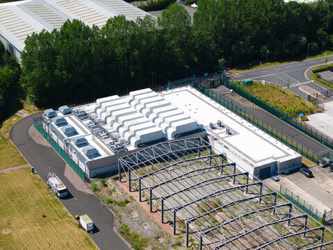 Aerial view of the ATOS data center facility featuring rooftop HVAC units and an adjacent steel frame structure in Birmingham, England, United Kingdom.