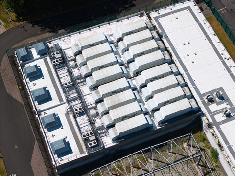 Aerial view of the ATOS data center featuring rows of industrial HVAC units on a white roof, surrounded by security fencing in Birmingham, England, United Kingdom.