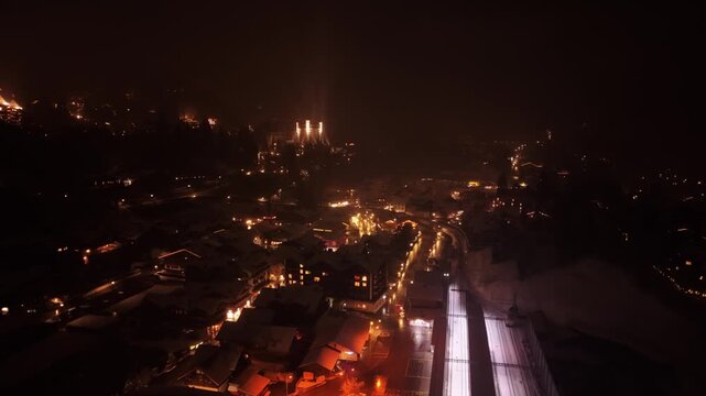 Aerial view of Gstaad at night with illuminated buildings and streets in the Swiss Alps, Saanen, Bern, Switzerland.