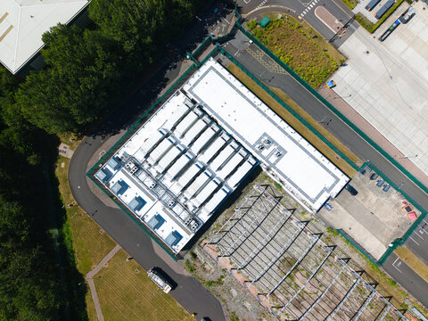 Aerial view of the ATOS data center facility in Birmingham, featuring industrial rooftops, HVAC units, surrounding security fencing, and adjacent paved areas in Birmingham, England, United Kingdom.