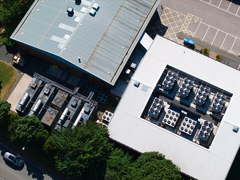 Aerial view of the Six Degrees Data Centre featuring industrial HVAC cooling ventilation units on the roof, surrounded by parking areas and greenery in Studley, England, United Kingdom.