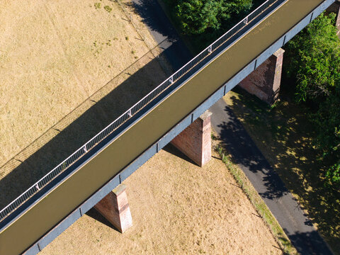 Aerial view of Edstone Aqueduct, a historic cast-iron canal bridge crossing over a road and fields in Wootton Wawen, England, United Kingdom.
