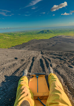 Person sandboarding on Cerro Negro, Nicaragua. View of a person on Cerro Negro riding a sandboard